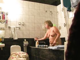 На скрытую камеру зрелая толстушка блондинка принимает освежающий душ